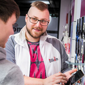 Mitarbeiter berät Kunden zu Smartphones und Tarifen im Handyshop mit großer Auswahl.